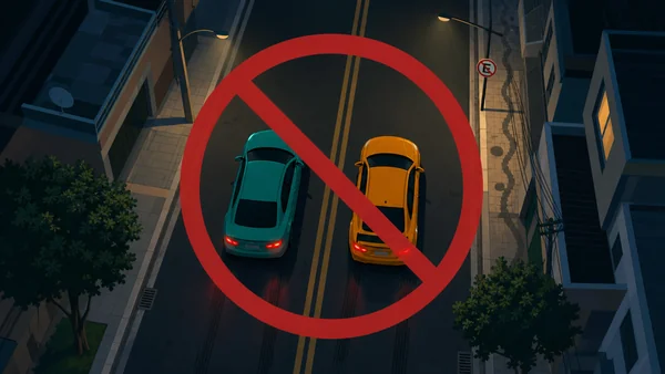 Dois carros lado a lado em via urbana com sinal de proibido